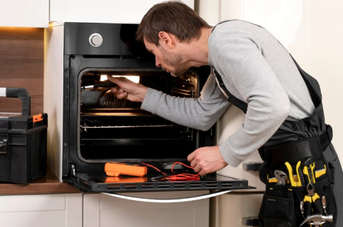 Artisan réparateur électroménager réparant un lave-linge chez un client