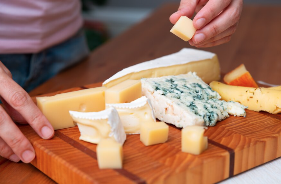 Fromager souriant dans sa boutique avec une vitrine professionnelle